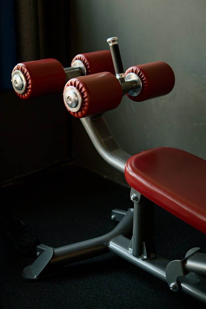 who-we-are Close-up of red padded gym equipment in a fitness center with natural lighting.